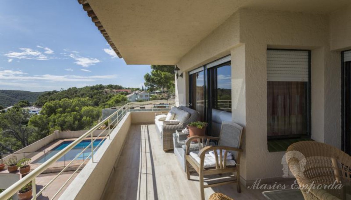 Vista de la terraza de la casa con vistas al jardín, piscina y montañas