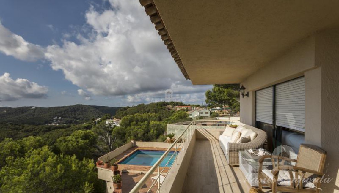 Vista de la terraza de la casa con vistas al jardín, piscina y montañas