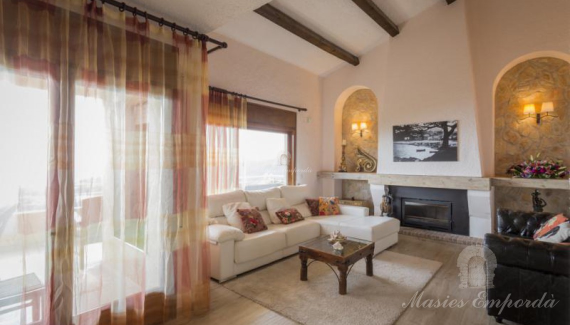 Salón principal de planta a doble altura de la casa con chimenea. 