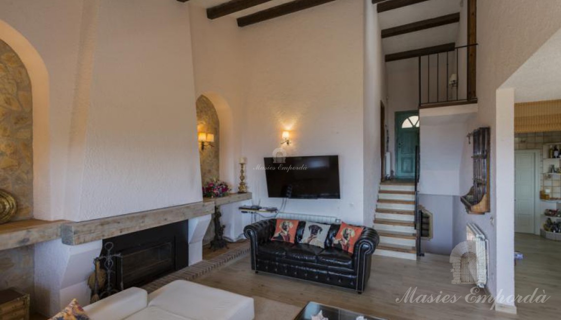 Salón principal de planta a doble altura de la casa con chimenea. 
