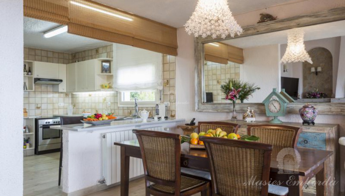 Comedor de la planta con la cocina con barra americana en un lateral de la imagen 