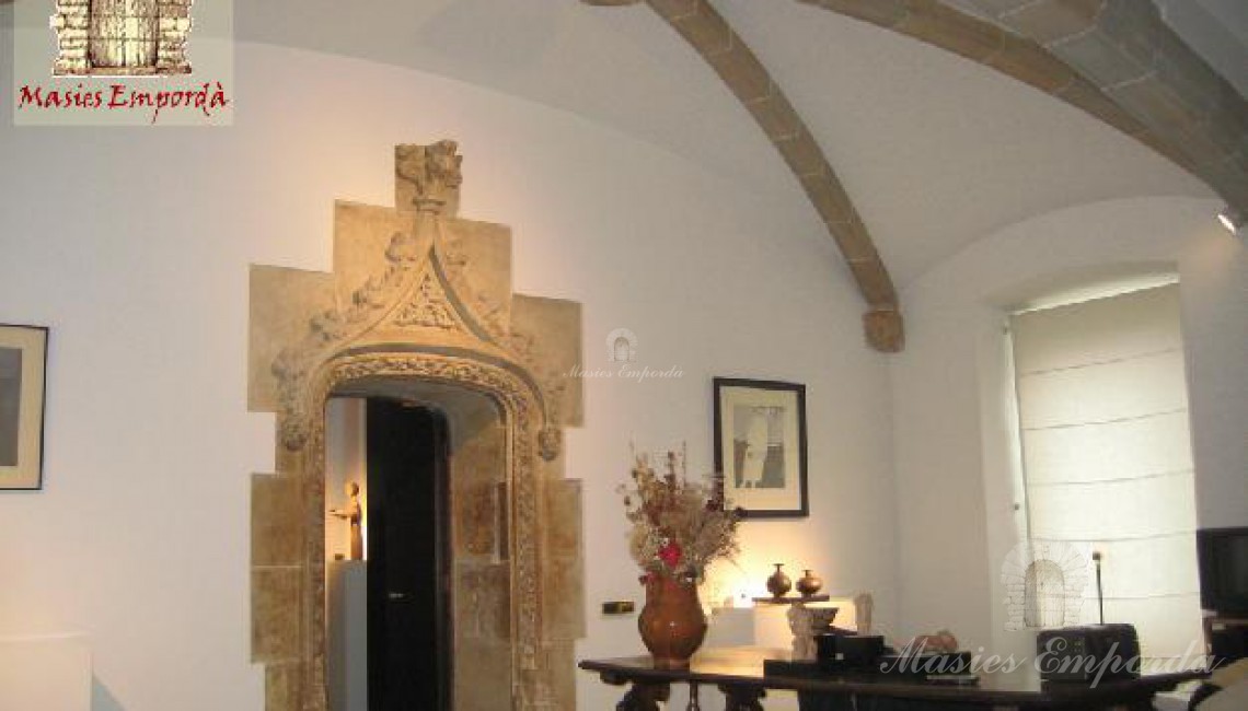 Salón del castillo abovedado con arco de medio punto de extremo a extremo de la sala con puerta con arco de piedra trabajada