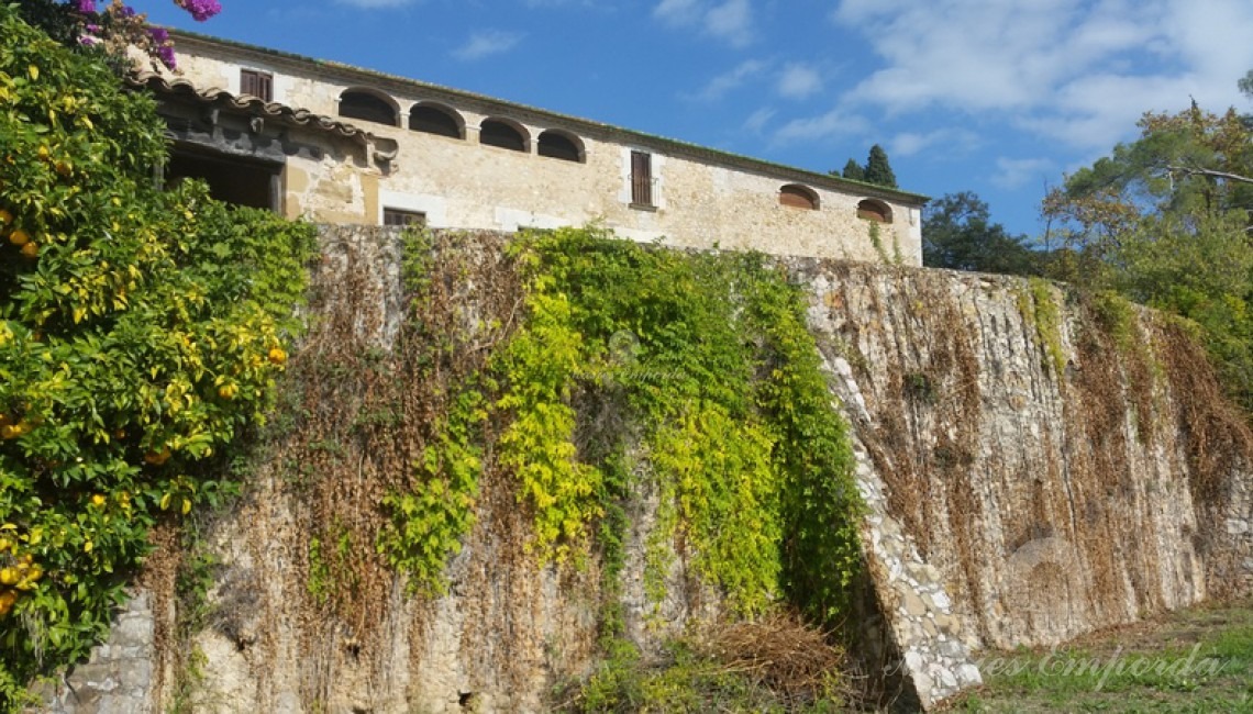Muralla con contrafuertes parte sur de la masía que cobija en su interior parte del jardín que rodea la casa  
