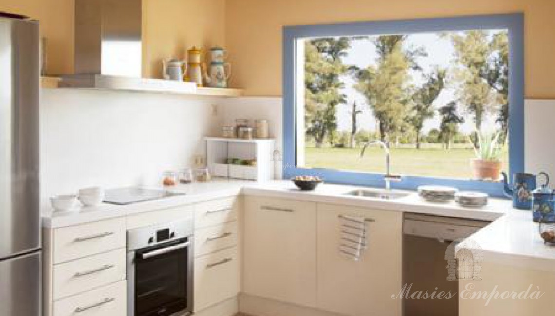 Detalle de la cocina con un gran ventanal con vistas a los campos que rodea la casa  