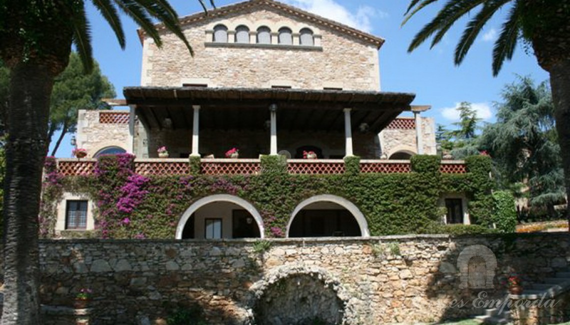 Fachada sureste de la Masía donde destacan los porches abovedaos de la casa y la gran terraza con vistas al jardín y al mar.    