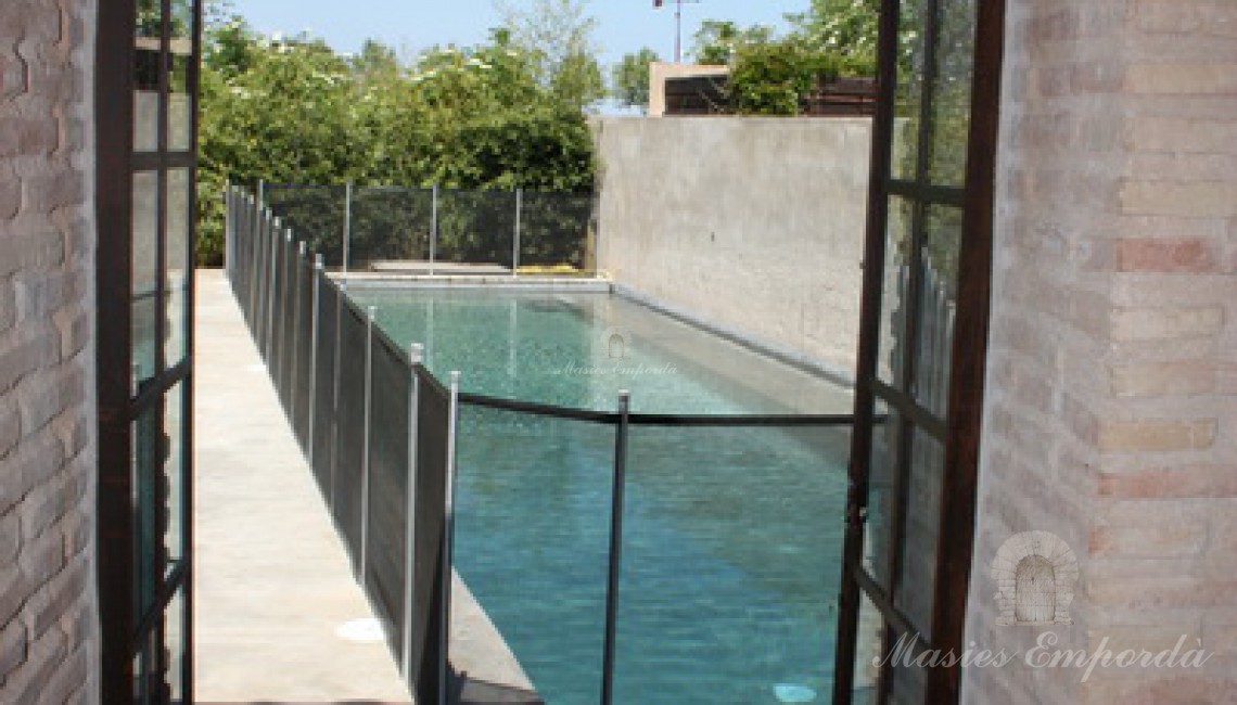 Vista de la piscina y el jardín desde el pabellón de verano 