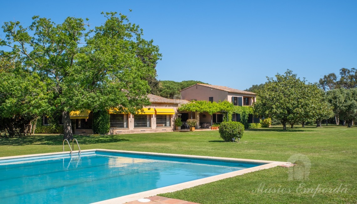 Vistas de la zona de piscina con la casa principal al fondo
