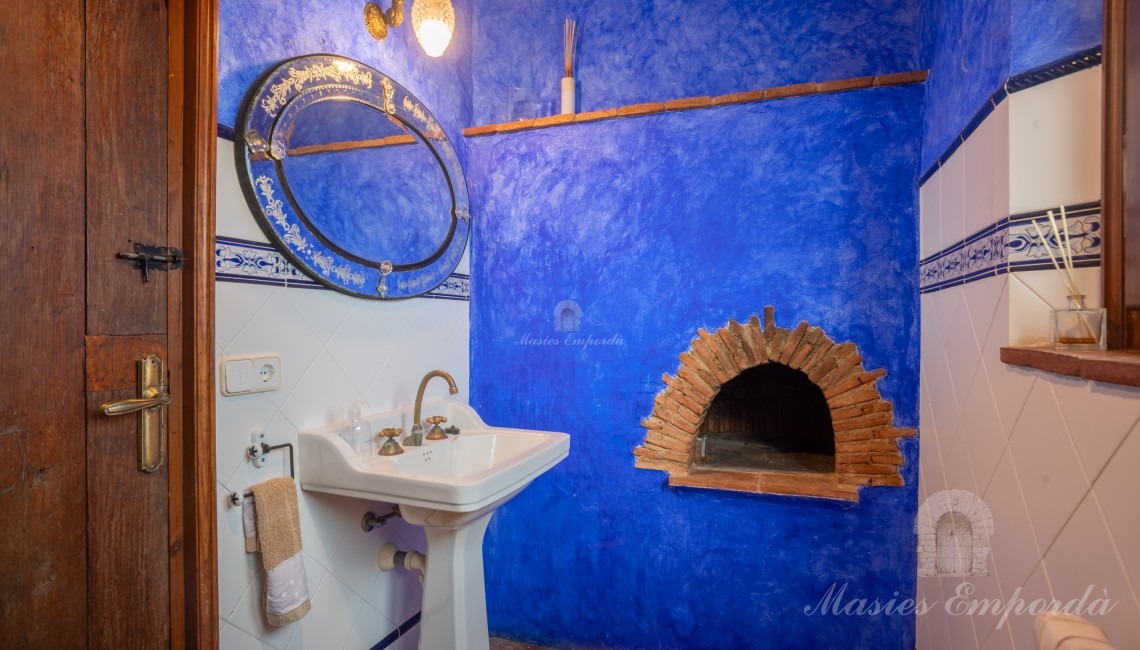 Baño de cortesía de planta baja con el antiguo horno refractario de la casa