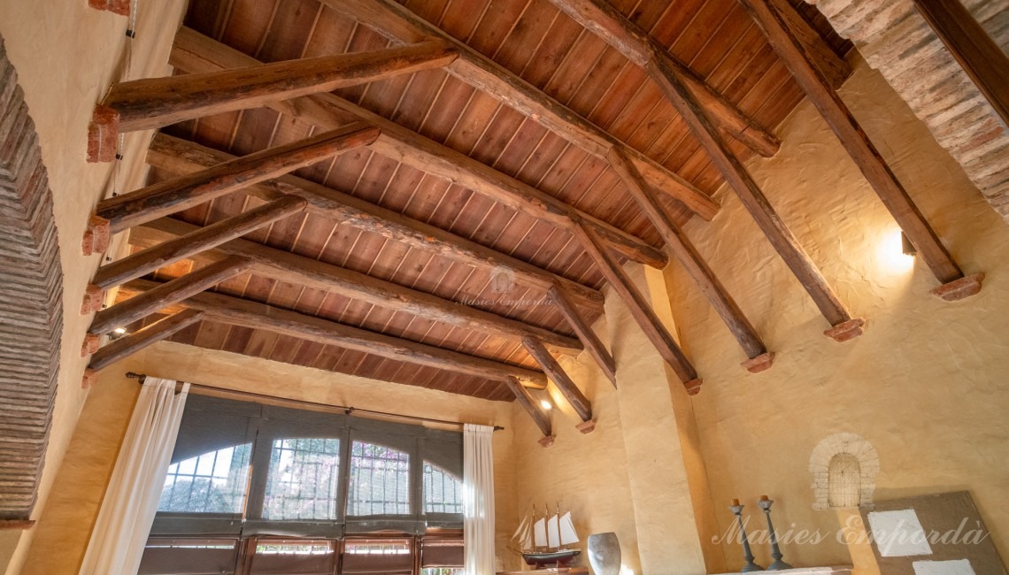 Vista del solón a doble altura con chimenea y vistas al jardín y salón comedor de la planta