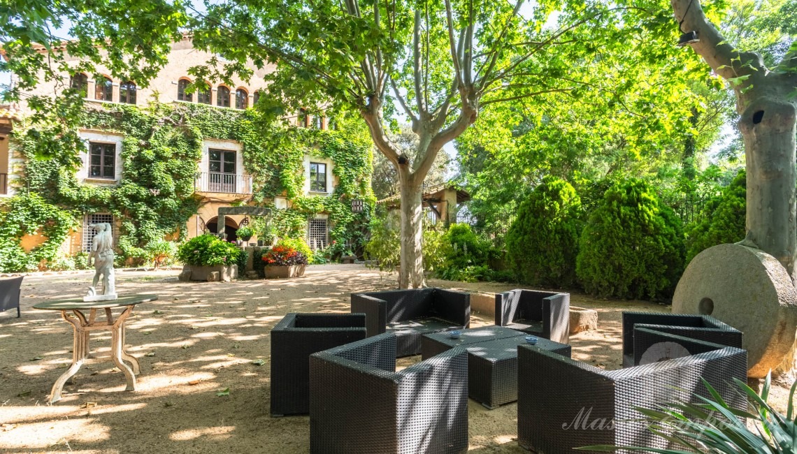 Fachada de la masía y jardín