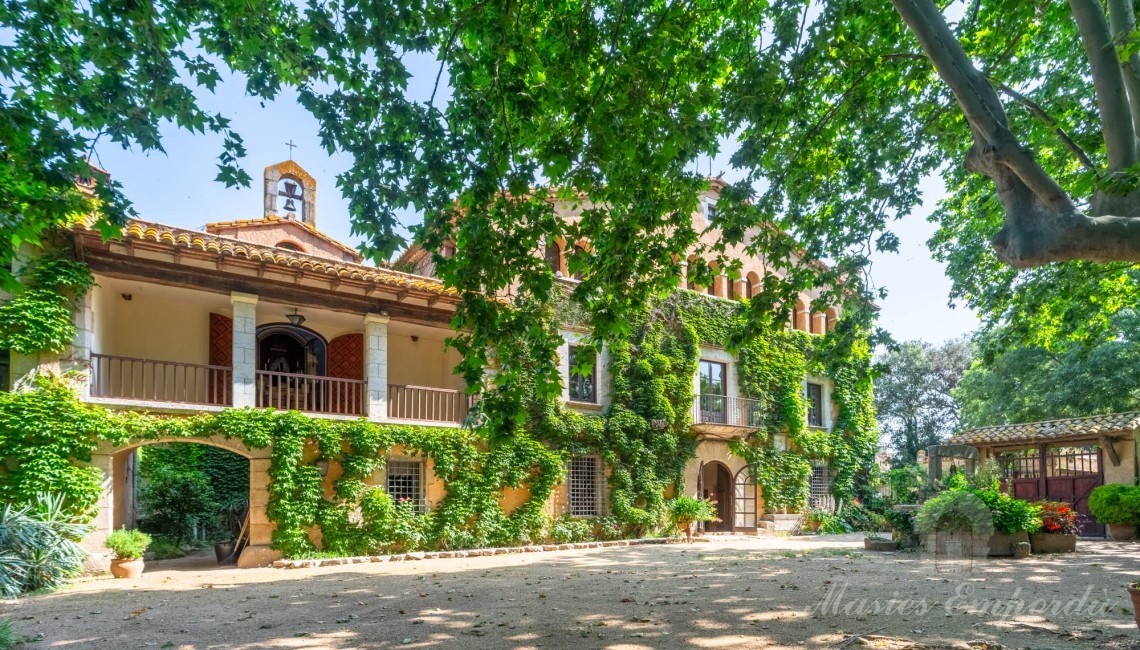 Fachada de la masía y jardín