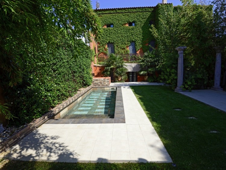 Vista de la fachada, jardín y piscina de la casa 