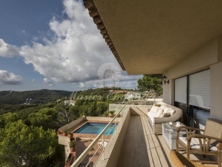 Vista de la terraza de la casa con vistas al jardín, piscina y montañas