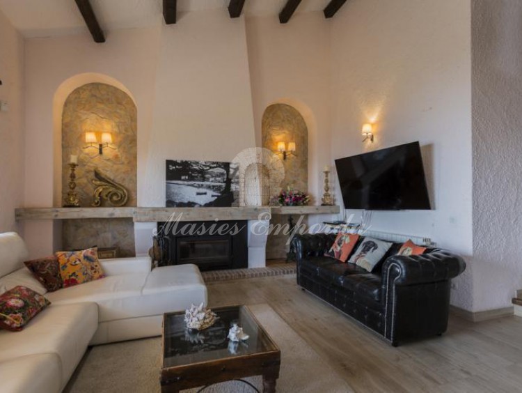 Salón principal de planta a doble altura de la casa con chimenea. 