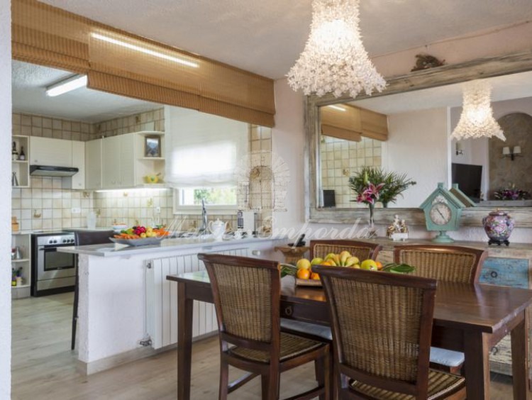 Comedor de la planta con la cocina con barra americana en un lateral de la imagen 